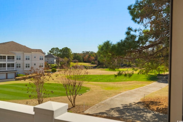 surrounding community featuring a lawn and view of golf course