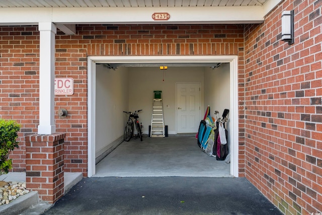 property entrance with a garage and brick siding