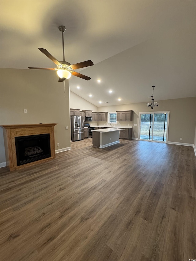 unfurnished living room with recessed lighting, a fireplace, vaulted ceiling, baseboards, and wood finished floors