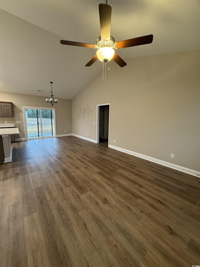 unfurnished living room with dark wood-type flooring, high vaulted ceiling, ceiling fan with notable chandelier, and baseboards