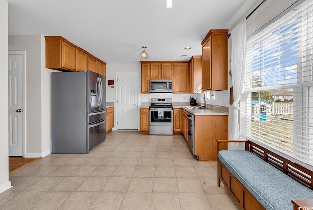 2629 Scarecrow Way, Myrtle Beach, SC 29579 - kitchen featuring appliances with stainless steel finishes, tasteful backsplash, brown cabinetry, light countertops, and baseboards