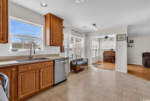 2629 Scarecrow Way, Myrtle Beach, SC 29579 - kitchen featuring stainless steel dishwasher, a sink, tasteful backsplash, brown cabinets, and a ceiling fan