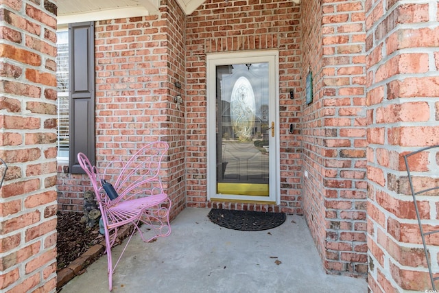 doorway to property with brick siding