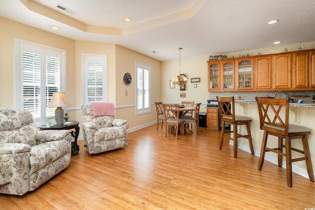 living room with an inviting chandelier, light wood-style flooring, recessed lighting, and visible vents