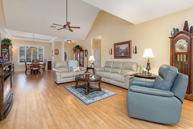 living room with light wood-style flooring, ceiling fan with notable chandelier, baseboards, and visible vents