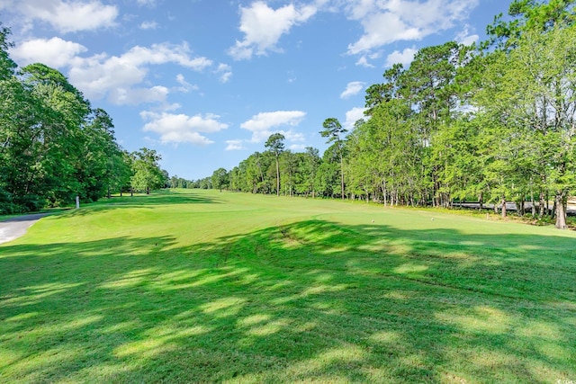 surrounding community with a yard and golf course view