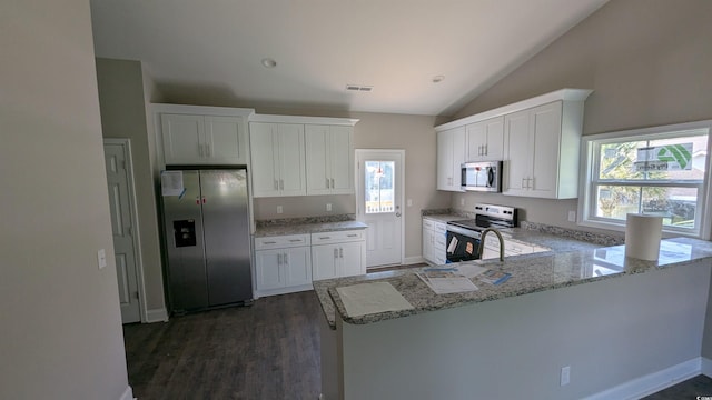 3566 Steamer Trace Rd, Conway, SC 29527 - kitchen featuring appliances with stainless steel finishes, lofted ceiling, light stone counters, plenty of natural light, and white cabinets