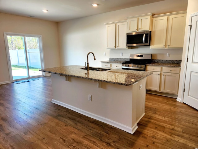 5088 Wavering Place Loop, Myrtle Beach, SC 29579 - kitchen featuring stainless steel appliances, a sink, an island with sink, dark wood finished floors, and dark stone countertops
