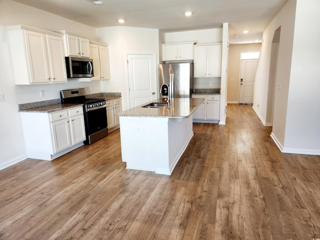 5088 Wavering Place Loop, Myrtle Beach, SC 29579 - kitchen featuring appliances with stainless steel finishes, a sink, light wood-style floors, stone countertops, and recessed lighting
