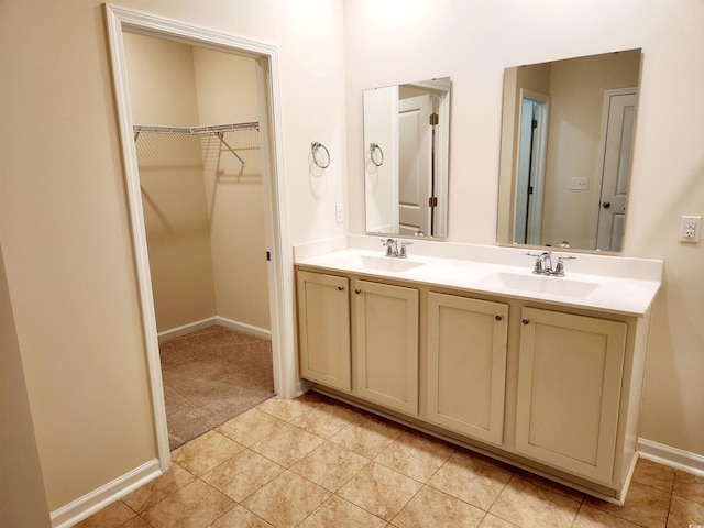 5088 Wavering Place Loop, Myrtle Beach, SC 29579 - bathroom with double vanity, a walk in closet, baseboards, and tile patterned floors
