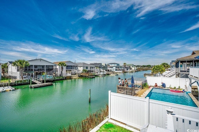 exterior space featuring a water view, fence, a residential view, and a pool
