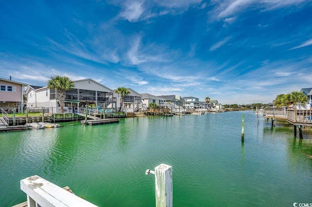 view of dock with a residential view and a water view