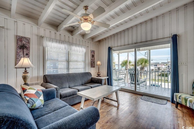 living area featuring vaulted ceiling with beams, ceiling fan, a healthy amount of sunlight, and hardwood / wood-style floors