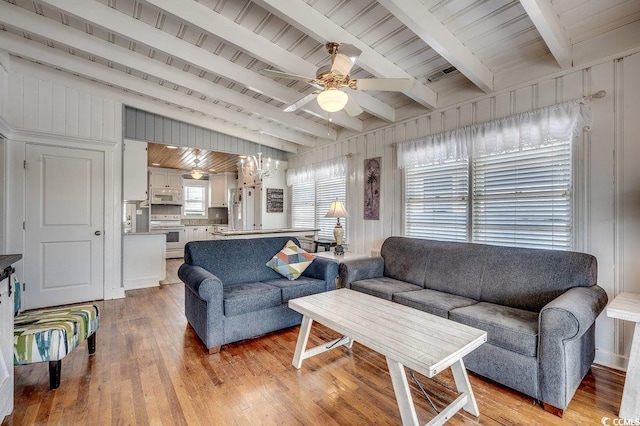 living area with ceiling fan, visible vents, beam ceiling, and light wood-style floors