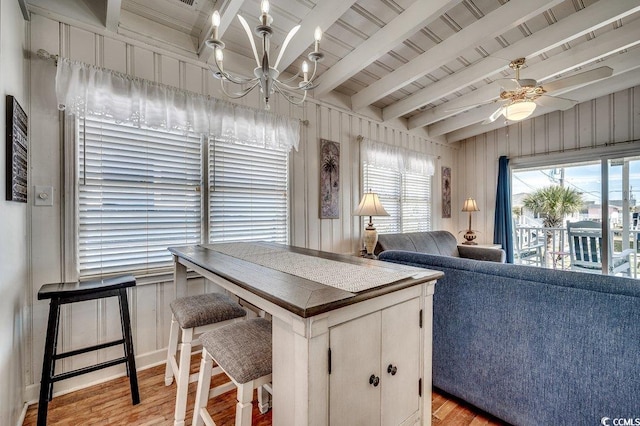 kitchen featuring beam ceiling, ceiling fan with notable chandelier, and light wood-style flooring
