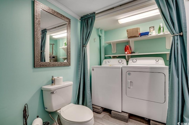 bathroom with independent washer and dryer, toilet, crown molding, and wood finished floors