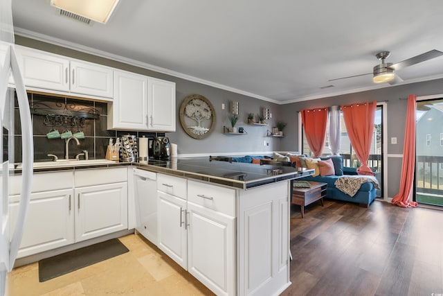 kitchen featuring ornamental molding, a peninsula, white dishwasher, white cabinets, and a sink