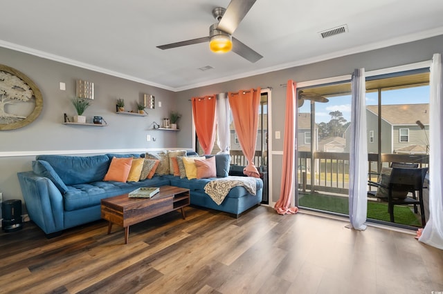 living room featuring visible vents, wood finished floors, a ceiling fan, and crown molding