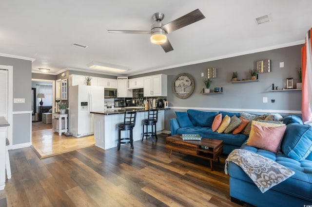 living room featuring visible vents, wood finished floors, a ceiling fan, and crown molding