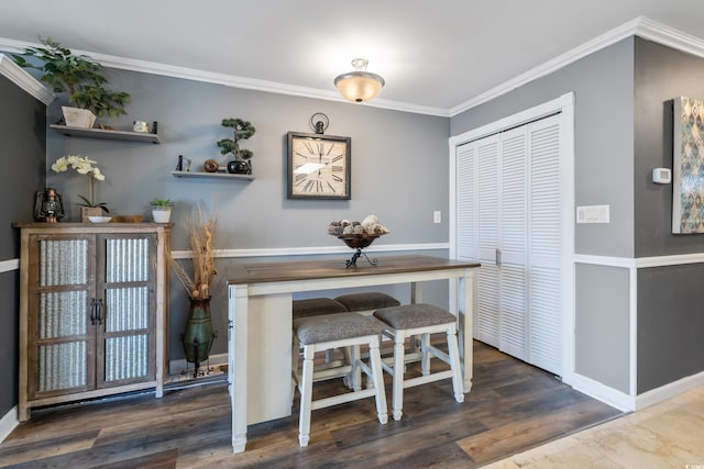 dining space featuring wood finished floors and ornamental molding