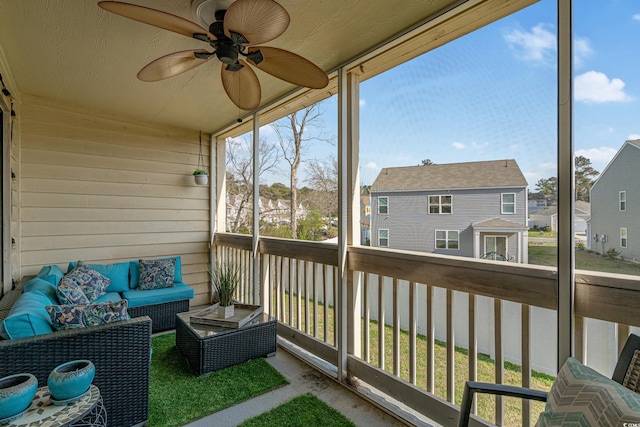 sunroom with a residential view, an outdoor living space, and a ceiling fan