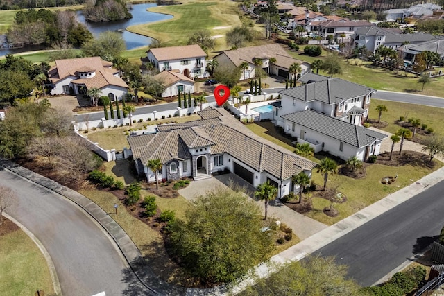 birds eye view of property with a water view, a residential view, and view of golf course