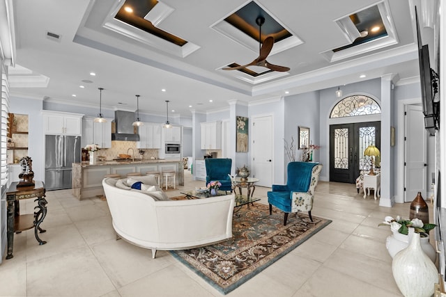 living area featuring a raised ceiling, crown molding, light tile patterned floors, and visible vents