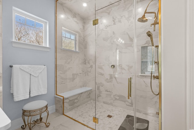full bath featuring a shower stall, marble finish floor, and baseboards