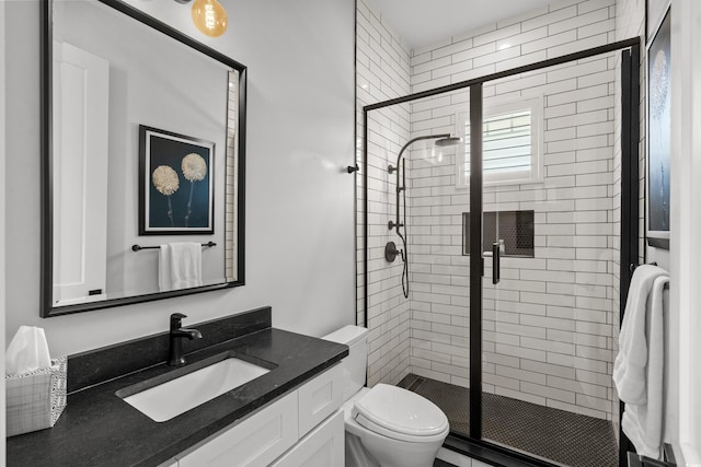 full bathroom with toilet, a stall shower, and vanity