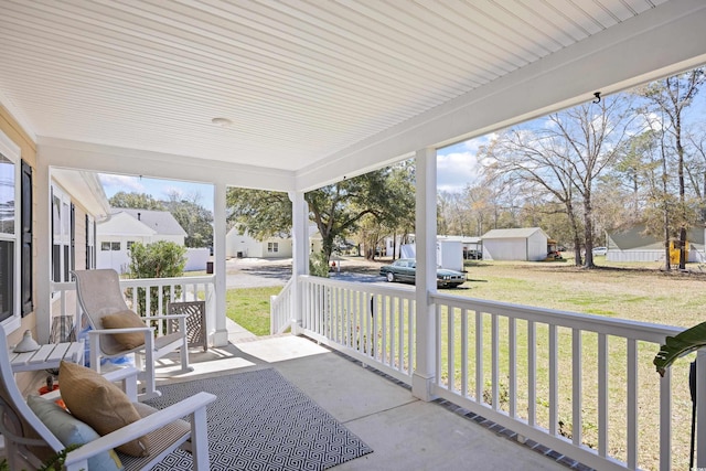 view of patio with a residential view, covered porch, and an outdoor structure