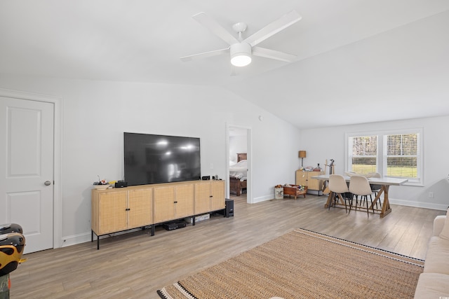 living room with vaulted ceiling, wood finished floors, baseboards, and ceiling fan