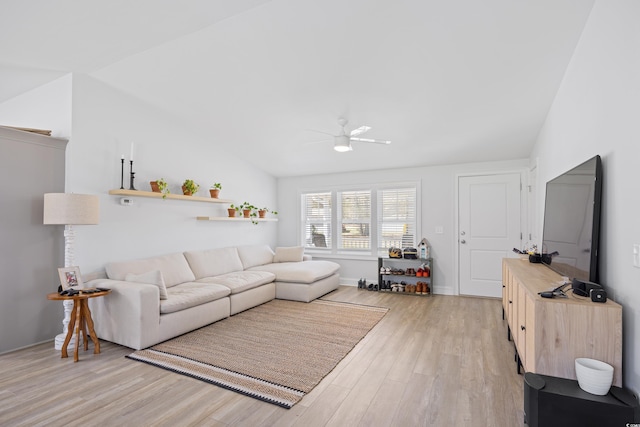 living room featuring vaulted ceiling, baseboards, light wood finished floors, and ceiling fan
