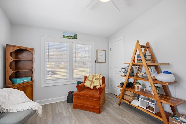 living area featuring baseboards, a ceiling fan, lofted ceiling, and wood finished floors