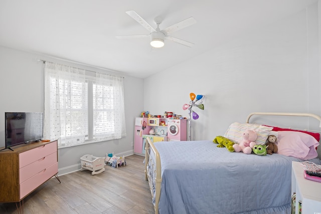 bedroom with light wood-type flooring, baseboards, lofted ceiling, and ceiling fan