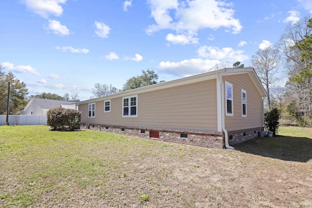 rear view of house featuring crawl space, a lawn, and fence