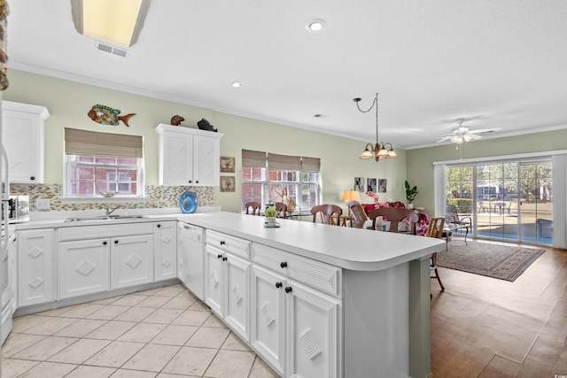 3927 Gladiola Ct Unit 101, Myrtle Beach, SC 29588 - kitchen featuring dishwasher, a sink, a peninsula, light countertops, and decorative backsplash