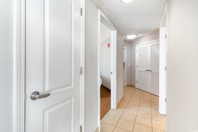 hallway featuring light tile patterned flooring and baseboards