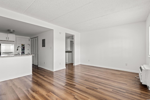 6850 Blue Heron Blvd Unit 205, Myrtle Beach, SC 29588 - unfurnished living room featuring a sink, dark wood-style floors, baseboards, and a textured ceiling