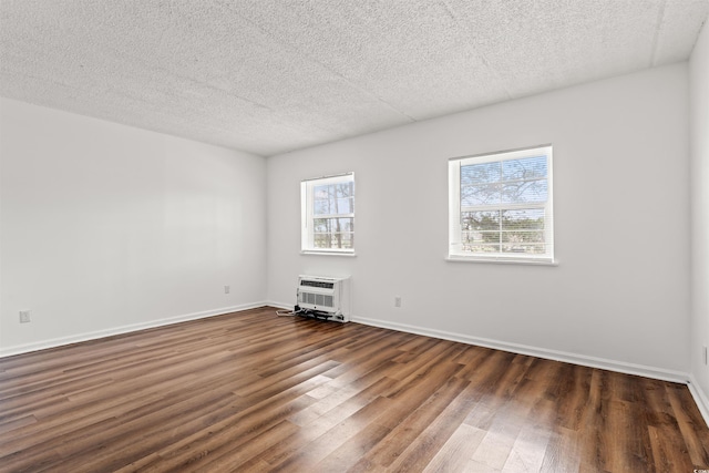 6850 Blue Heron Blvd Unit 205, Myrtle Beach, SC 29588 - empty room featuring a wall mounted air conditioner, baseboards, dark wood-style flooring, and a wealth of natural light