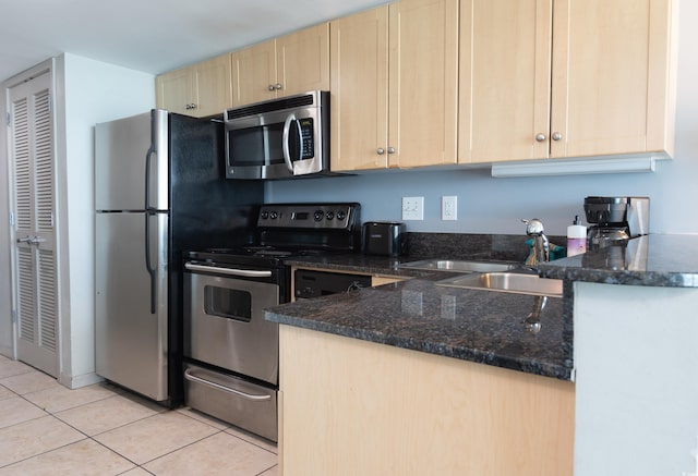 107 S Ocean Blvd Unit 704, Myrtle Beach, SC 29577 - kitchen with a sink, stainless steel appliances, dark stone counters, light tile patterned floors, and light brown cabinets