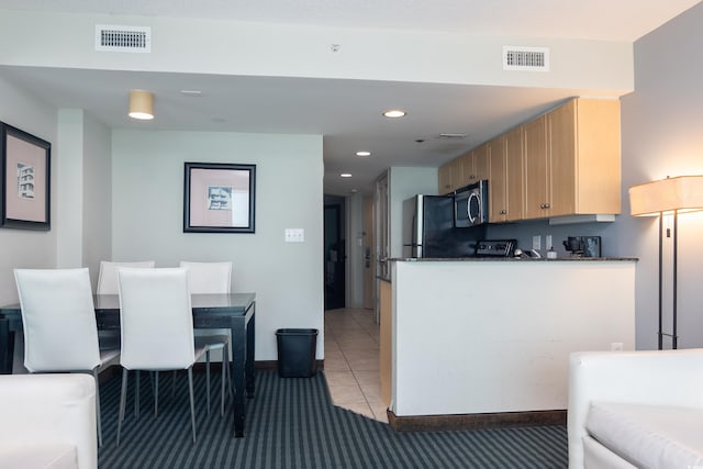 107 S Ocean Blvd Unit 704, Myrtle Beach, SC 29577 - kitchen with dark countertops, refrigerator, visible vents, and stainless steel microwave
