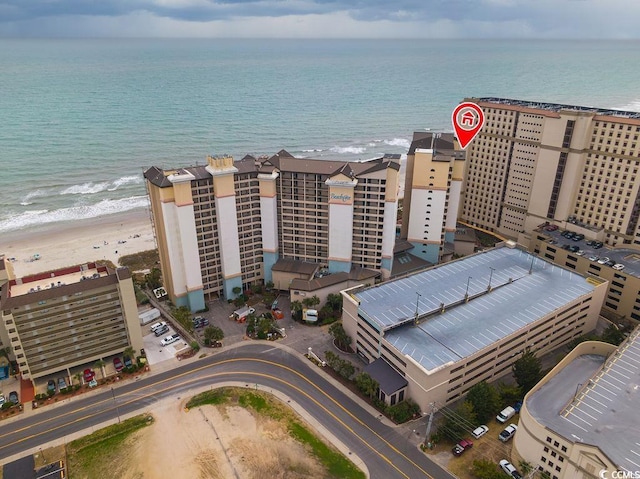 birds eye view of property with a water view and a beach view