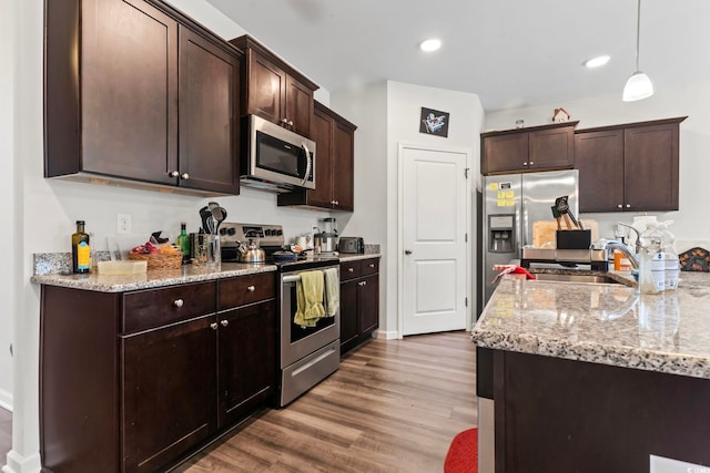 2848 Ophelia Way, Myrtle Beach, SC 29577 - kitchen featuring stainless steel appliances, a sink, dark brown cabinetry, wood finished floors, and light stone counters