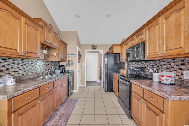 kitchen with light tile patterned floors, a sink, black appliances, and decorative backsplash