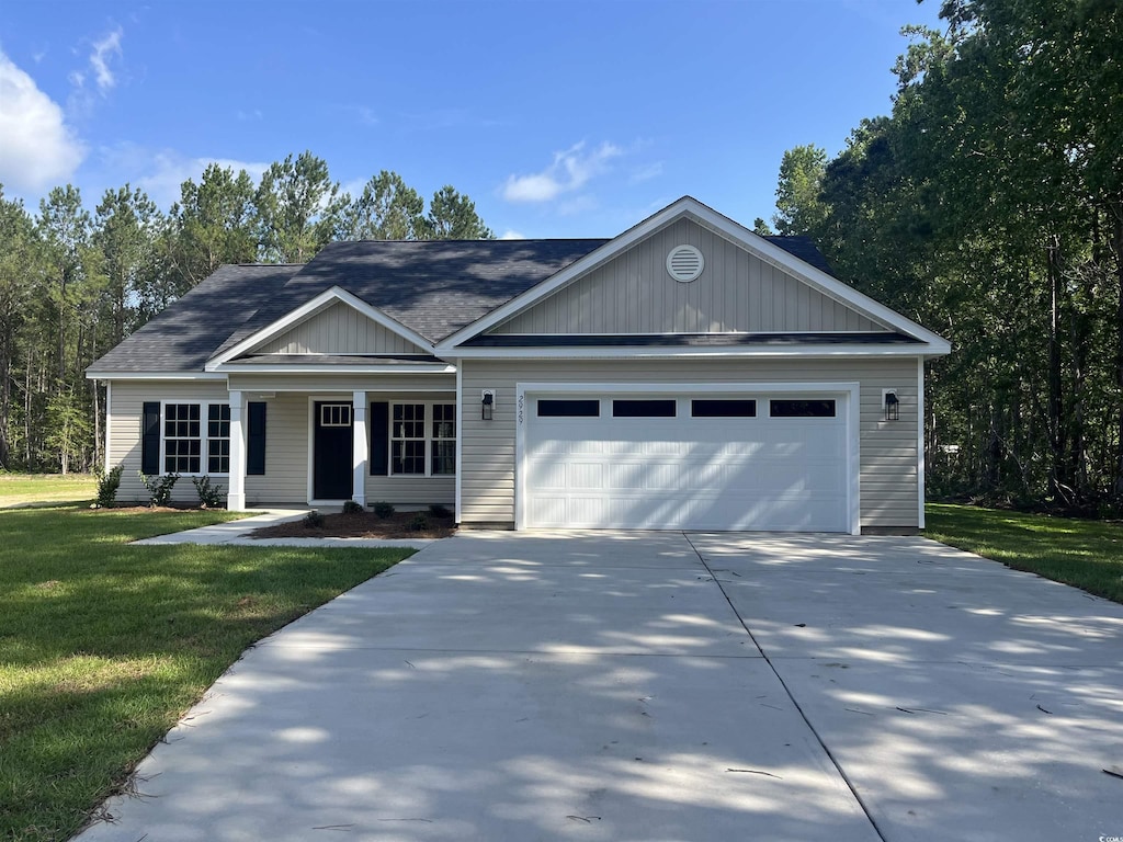 2929 Hughes Gasque Rd, Aynor, SC 29511 - ranch-style home with a garage, a front yard, concrete driveway, covered porch, and a shingled roof