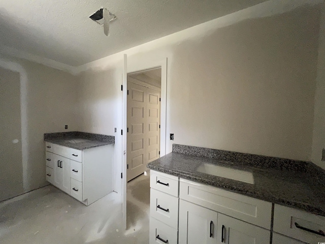 2929 Hughes Gasque Rd, Aynor, SC 29511 - kitchen featuring white cabinets, dark stone countertops, and concrete floors