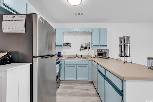 500 Fairway Village Dr Unit 7-D, Myrtle Beach, SC 29588 - kitchen featuring a sink, stainless steel appliances, blue cabinetry, washer / dryer, and light countertops