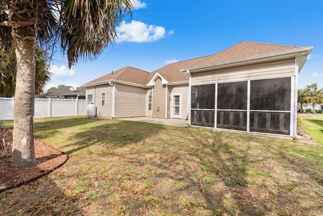 rear view of property with a patio area, a sunroom, a yard, and fence