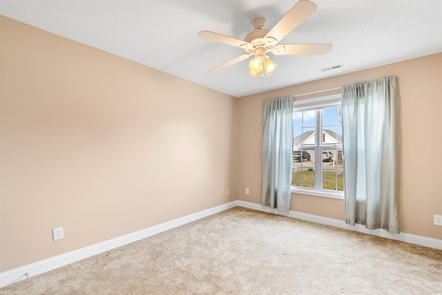 carpeted empty room featuring visible vents, baseboards, a textured ceiling, and ceiling fan