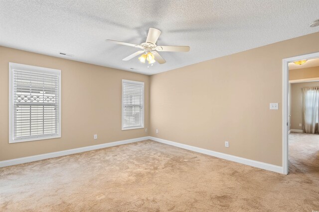 spare room featuring baseboards, plenty of natural light, light colored carpet, and ceiling fan